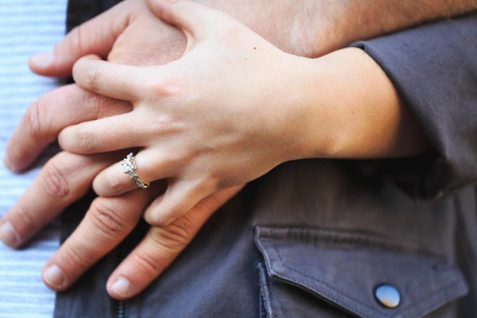 Couple holding hands together and wife shows off her engagement ring Couple holding hands together and wife shows off her engagement ring
